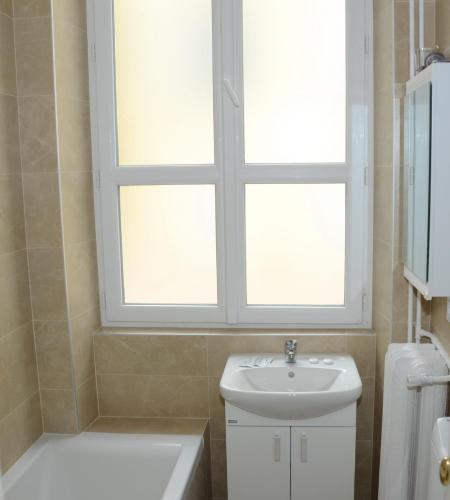La salle de bains est pourvue d'un lavabo et d'une fenêtre au-dessus des toilettes. dans l'établissement Apartement GT, à Nice