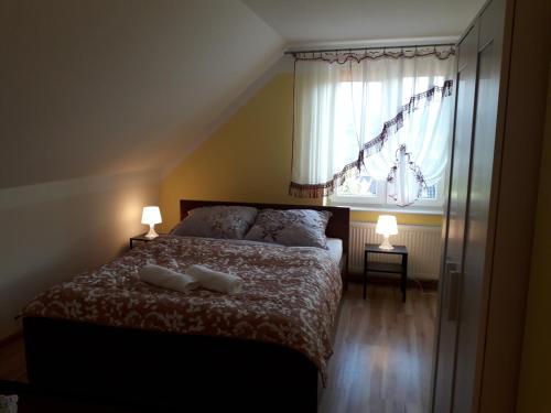a bedroom with a bed with two pillows and a window at Dom nad Jeziorem in Mucharz