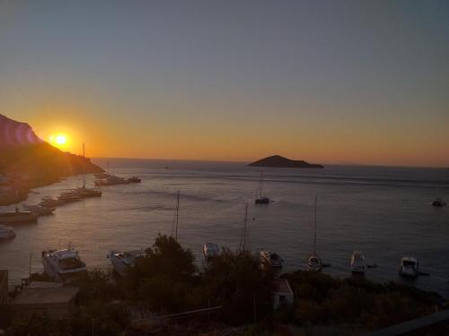 a sunset over a harbor with boats in the water at Aegean Blue in Panteli