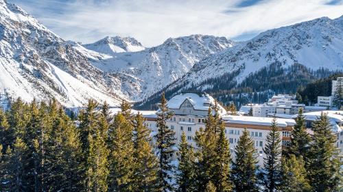 a hotel in the mountains with snow covered mountains at Waldhotel Arosa in Arosa