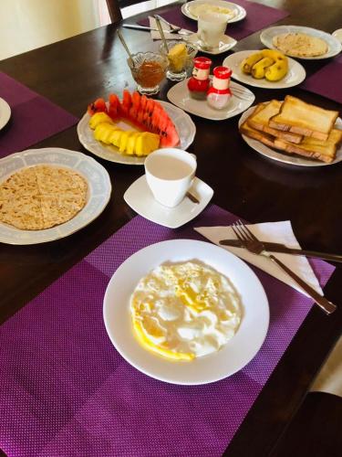 康提Hewune Uptown Stay的紫色桌子上带食物盘的桌子