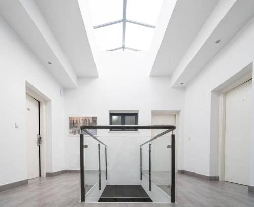 a staircase in a white room with a cross hanging from the ceiling at Apartamentos La Laguna in Fuente de Piedra