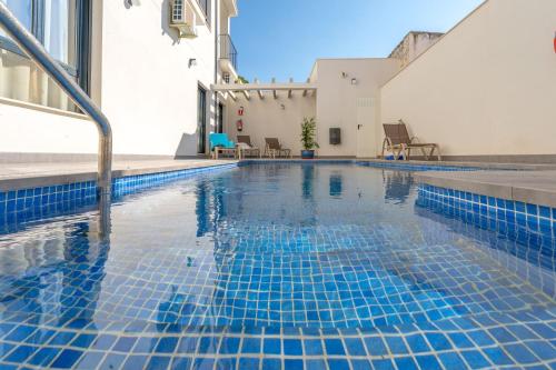 a swimming pool with blue tiles in a building at Apartamentos La Laguna in Fuente de Piedra