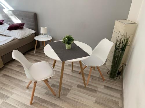 ウィーンにあるSchönbrunn Apartmentのテーブル、椅子2脚、ベッド1台が備わる客室です。