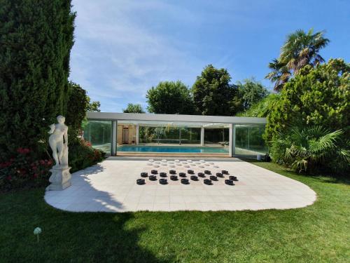 una casa junto a la piscina con un tablero de ajedrez en el patio en Chateau Moncassin en Leyritz-Moncassin