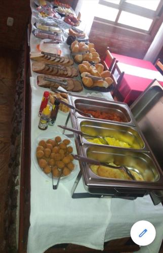 una linea a buffet con molti tipi diversi di cibo di Paratibela Pousada a Anchieta