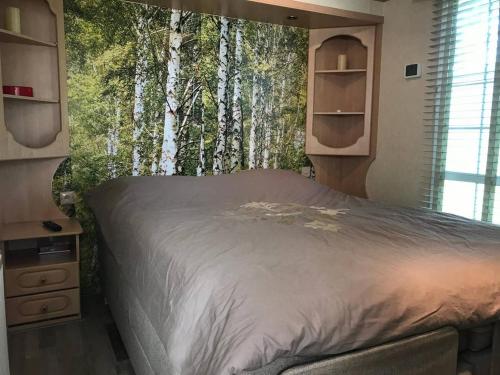 a bedroom with a bed with a mural of trees at ANVIBE 1 in Lathum