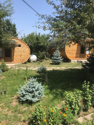 a garden with a wooden building and a house at Harsnadzor Eco Resort in Halidzor