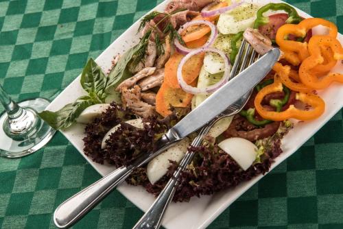 a plate of food with meat and vegetables on a table at Speke Hotel 1996 Ltd in Kampala