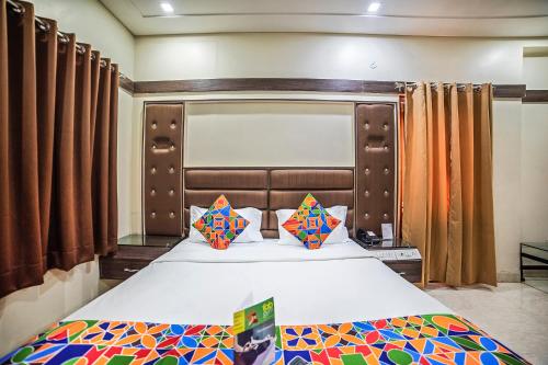 a bedroom with a large bed with a large headboard at FabHotel Santoor Geeta Bhawan Square in Indore