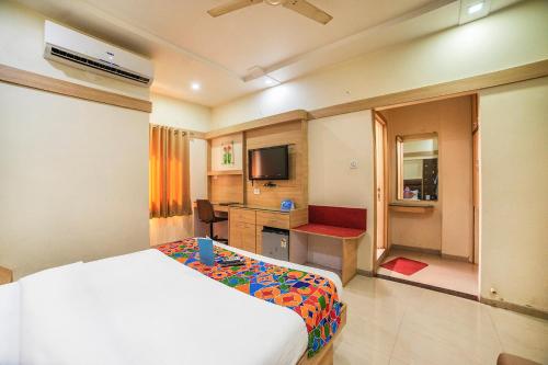 a hotel room with a bed and a television at FabHotel Santoor Geeta Bhawan Square in Indore
