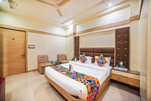a bedroom with a large bed and a desk at FabHotel Santoor Geeta Bhawan Square in Indore