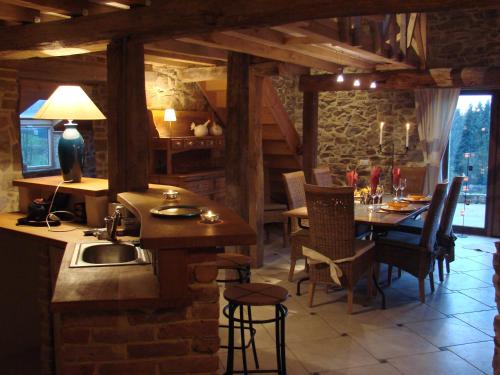 una cucina e una sala da pranzo con un lavandino e un tavolo di La Cense De Renière a Ferrières