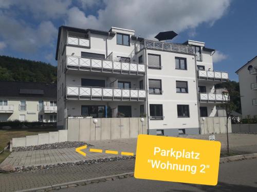 a white building with a yellow sign in front of it at Ferienwohnung Wellenreiter in Sassnitz