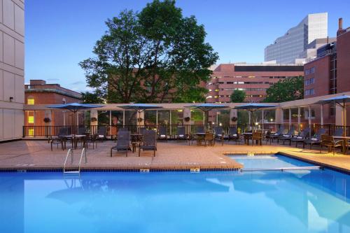 a swimming pool with tables and chairs and umbrellas at Wyndham Boston Beacon Hill in Boston