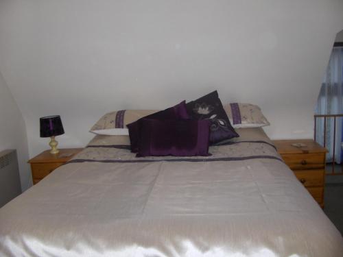 a bed with a white bedspread and pillows on it at Caurelgranges in Caurel