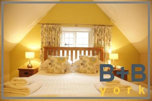 a bedroom with a bed with a large window at B+B York in York