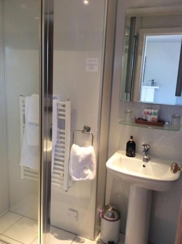 a white bathroom with a sink and a shower at Furan GuestHouse in Inverness