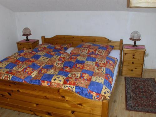 - une chambre avec un lit en bois et 2 tables de chevet dans l'établissement Ferienwohnung Oblfing, à Schöllnach