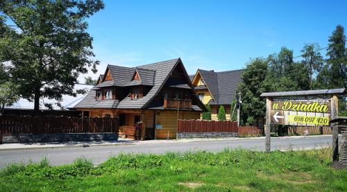 a large wooden house with a sign in front of it at U Dziadka in Chochołów