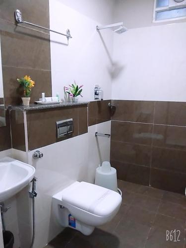 a bathroom with a toilet and a sink at Grand Oliver in Chennai