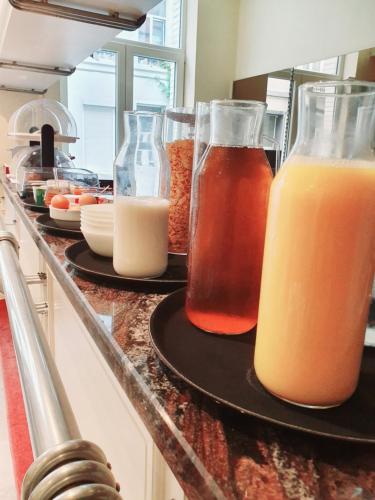 a counter with three bottles of orange juice and milk at Hotel Queen Mary in Brussels