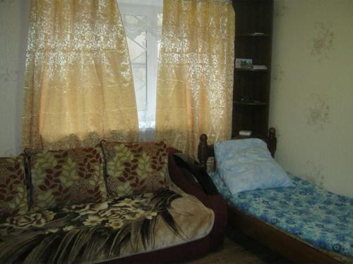 a room with a couch and a window with curtains at Apartment in Pyatigorsk in Pyatigorsk