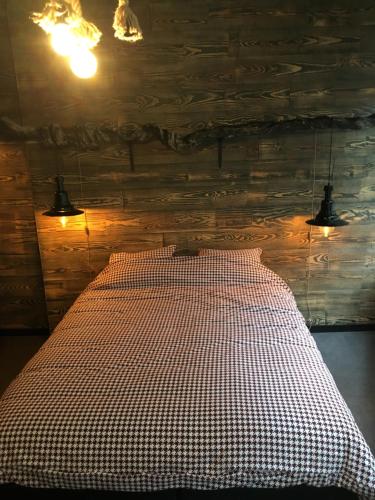 a bedroom with a bed with a checkered blanket at Le Santos in Namur