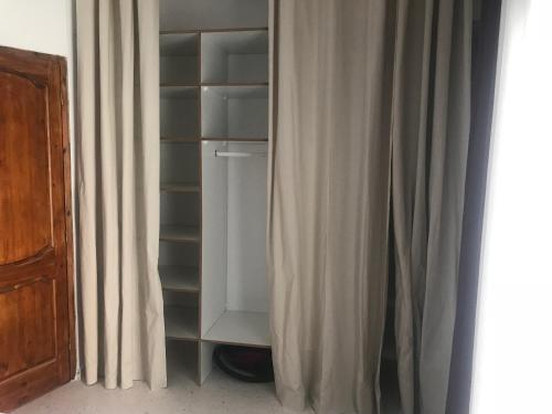 an empty closet with a curtain next to a window at résidence les oliviers in Soliman