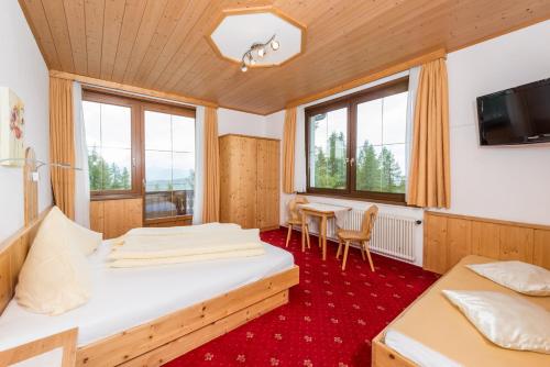 1 dormitorio con 2 camas, mesa y sillas en Gasthof Hunerkogel, en Ramsau am Dachstein