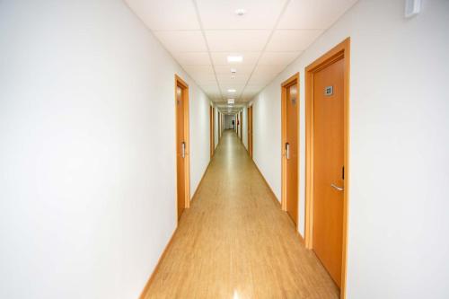 an empty corridor in an office building with a long hallway at Hotel Zandoná in Blumenau