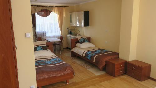 um pequeno quarto com 2 camas e um lavatório em Rodzinny dom. em Augustów