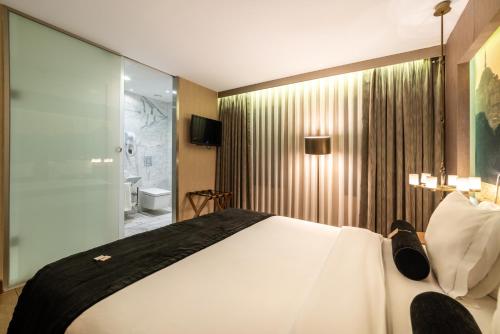 a bedroom with a large white bed and a bathroom at Hotel Saint Sophia in Istanbul
