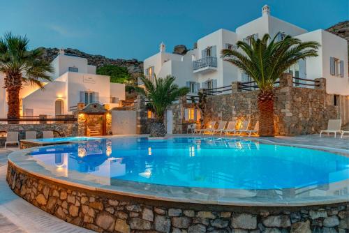 a large swimming pool in front of a villa at Makis Place in Tourlos