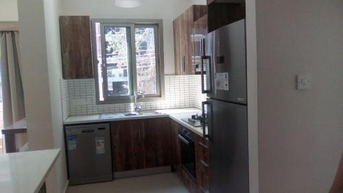 a kitchen with a stainless steel refrigerator and a window at Aqua Royal Alexus Luxury Holiday Apartments Girne in Kérynia