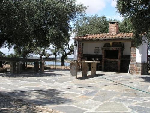 a stone patio with a building with a fireplace at Monte Do Caneiro in Mourão