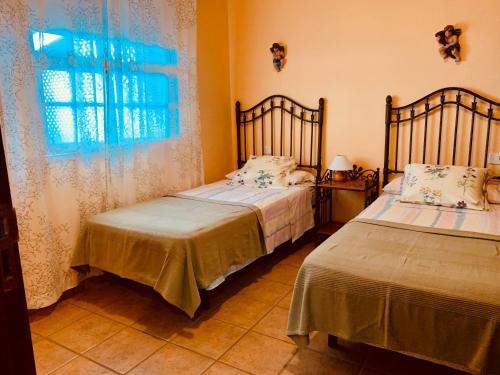two beds in a room with a window at Apartamentos Isla Encantada in Puntallana