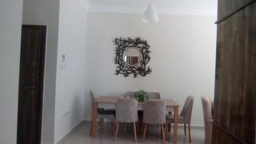 a dining room with a table and a mirror on the wall at Aqua Royal Alexus Luxury Holiday Apartments Girne in Kérynia
