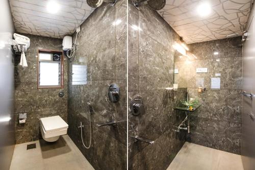 a bathroom with a shower and a toilet at Hotel Radana Vashi Navimumbai in Navi Mumbai
