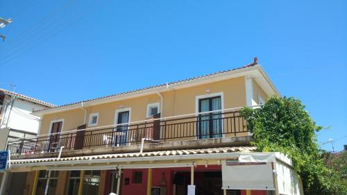una casa gialla con balcone su una strada di Sunrise Studios Alykes a Alykes