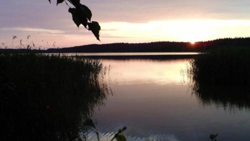 a view of a lake with the sunset in the background at Ferienpark-Canow in Canow