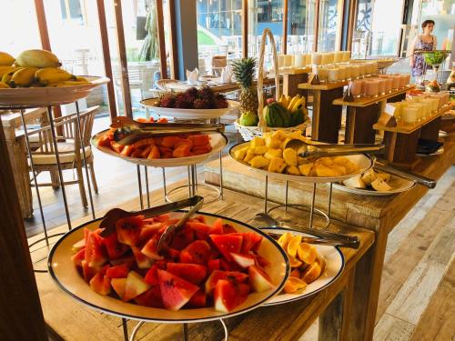 a buffet with several plates of fruit on a table at Thaproban Pavilion Waves in Unawatuna
