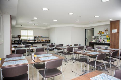 a room with tables and chairs in a restaurant at Palais Hotel in São Vicente