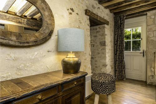 a lamp sitting on top of a dresser in a room at Domaine De Villeray in Condeau