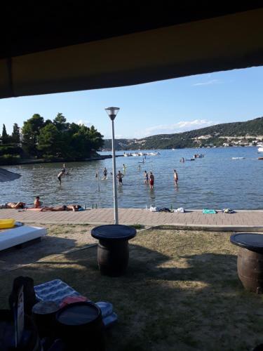 a group of people in the water at a beach at Apartmani Premijer-Rab in Supetarska Draga