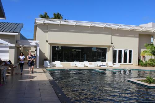 two people walking by a pool at a resort at Swiss Nest Travel in Roches Noires