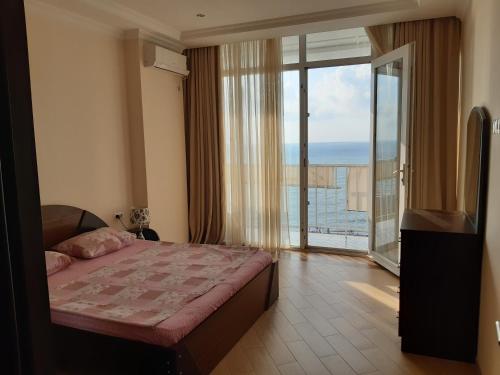 a bedroom with a bed and a view of the ocean at Beautiful House By the sea in Batumi