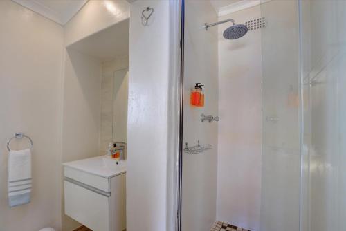 a white bathroom with a shower and a toilet at No.8 on Wright Street in George