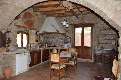 una cucina con tavolo e sedie in una stanza di Sa Domu de sa Contissa a Sèlegas