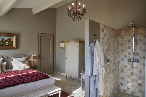 a bedroom with a bed and a chandelier at Le Pré de l'Aube in Montjoyer